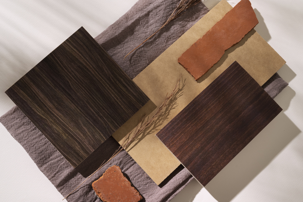 Composición decorativa con muestras de madera oscura, terracota y texturas naturales, ideal para ilustrar la elección de materiales para muebles.